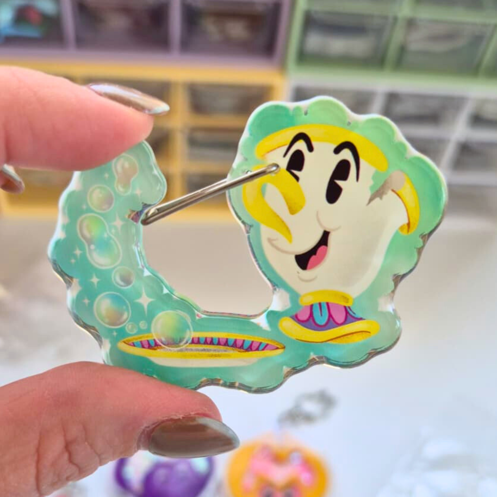 Cartoon character keychain held by a hand with a blurred background