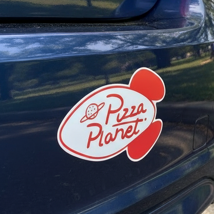 Toy Story Pizza Planet car magnet with character holding a pizza box in a colorful setting.