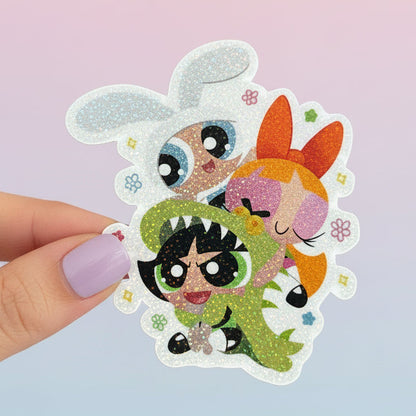 Hand holding a sticker with cartoon characters against a blurred natural background