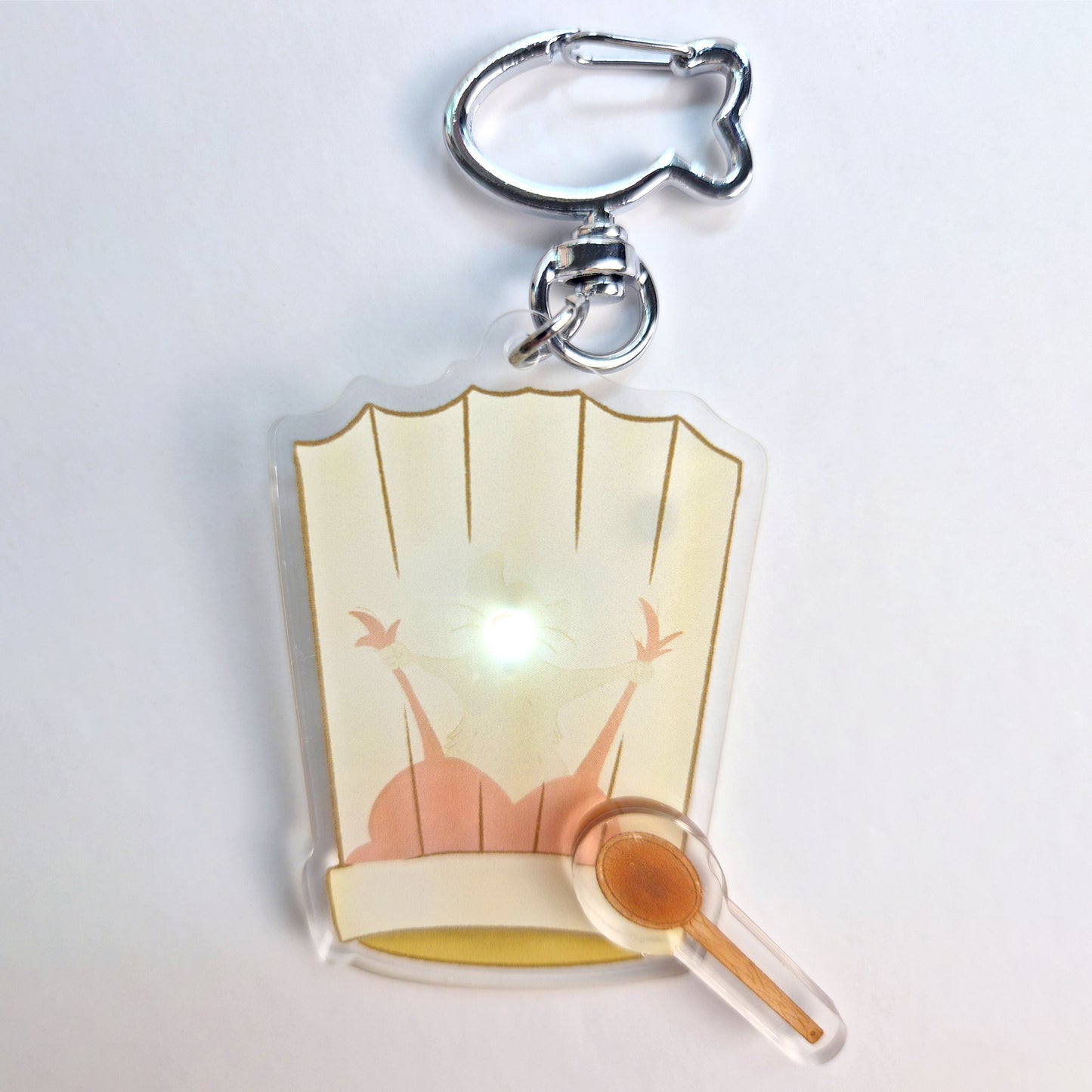 Ratatouille Remy light-up keychain dark room showing pink glow activated