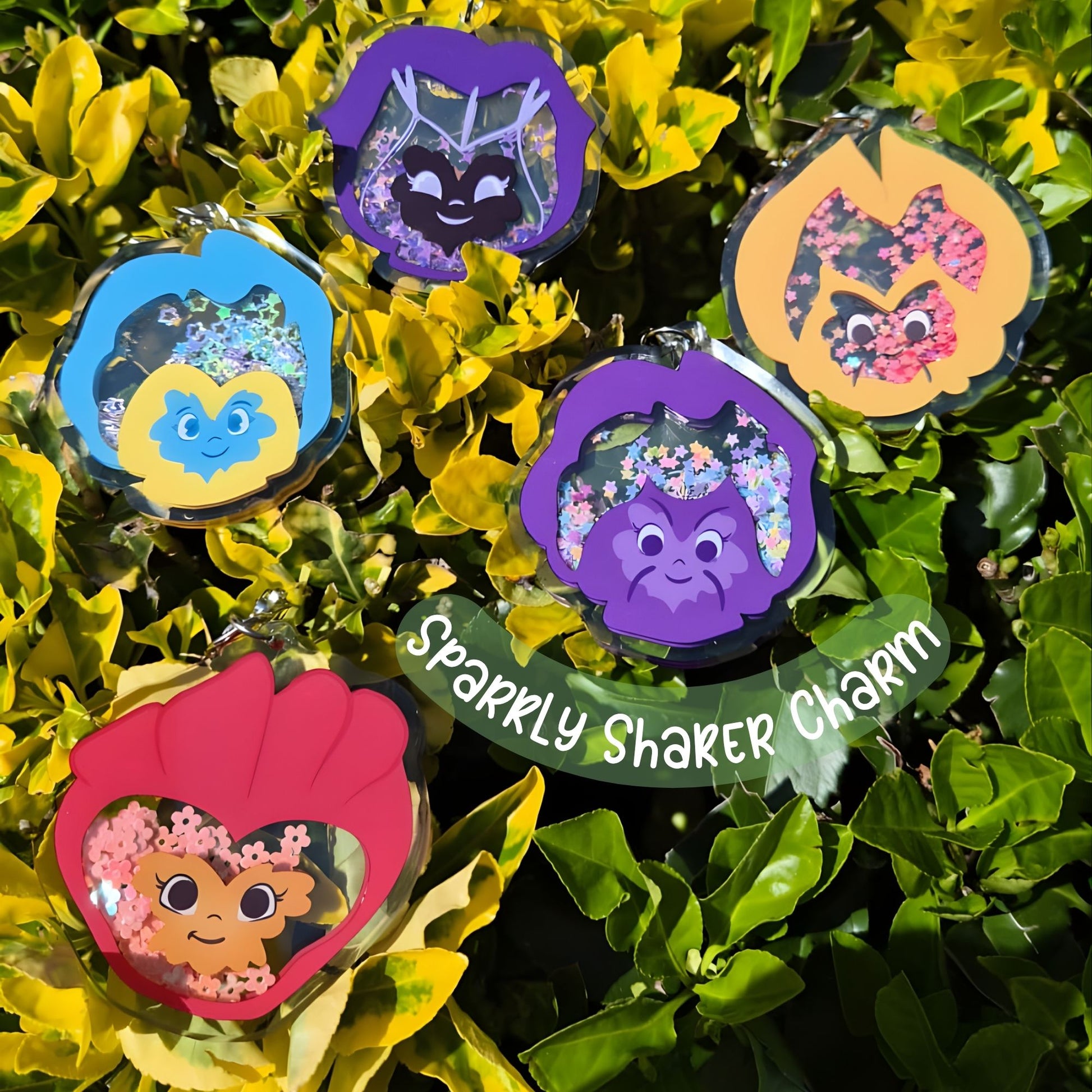 Set of colorful charms with floral designs on a green leaf background