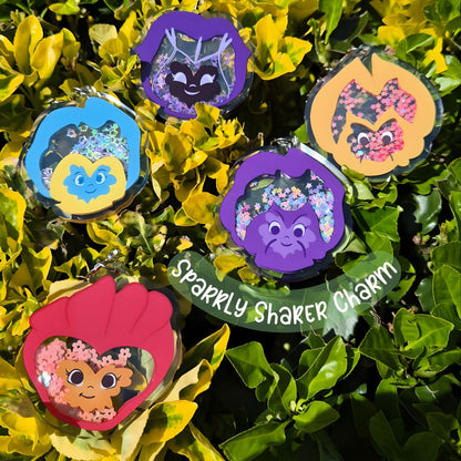 Set of colorful charms with floral designs on a green leaf background