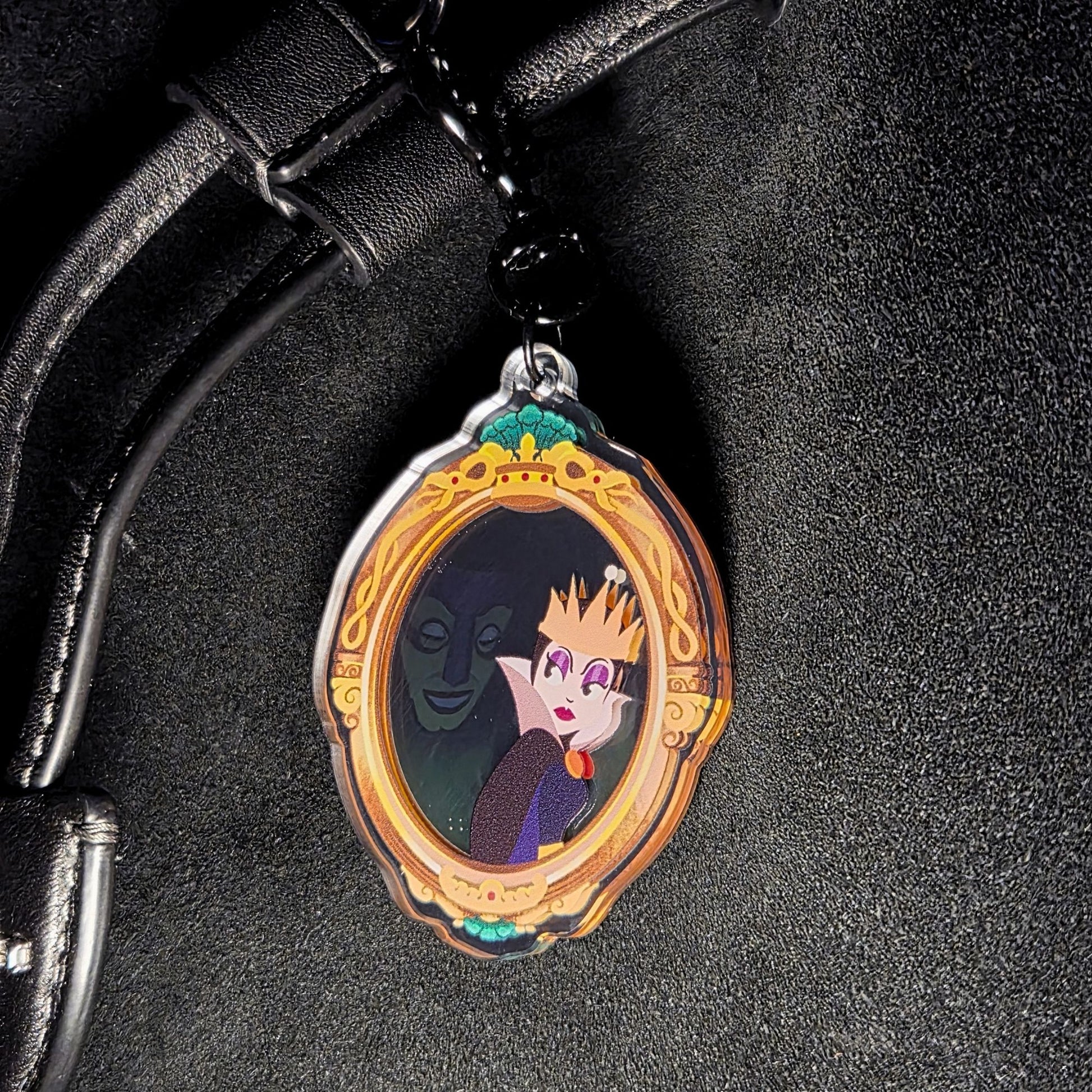 Close-up of Wicked Queen mirror bag charm showing the villain queen illustration inside the frame