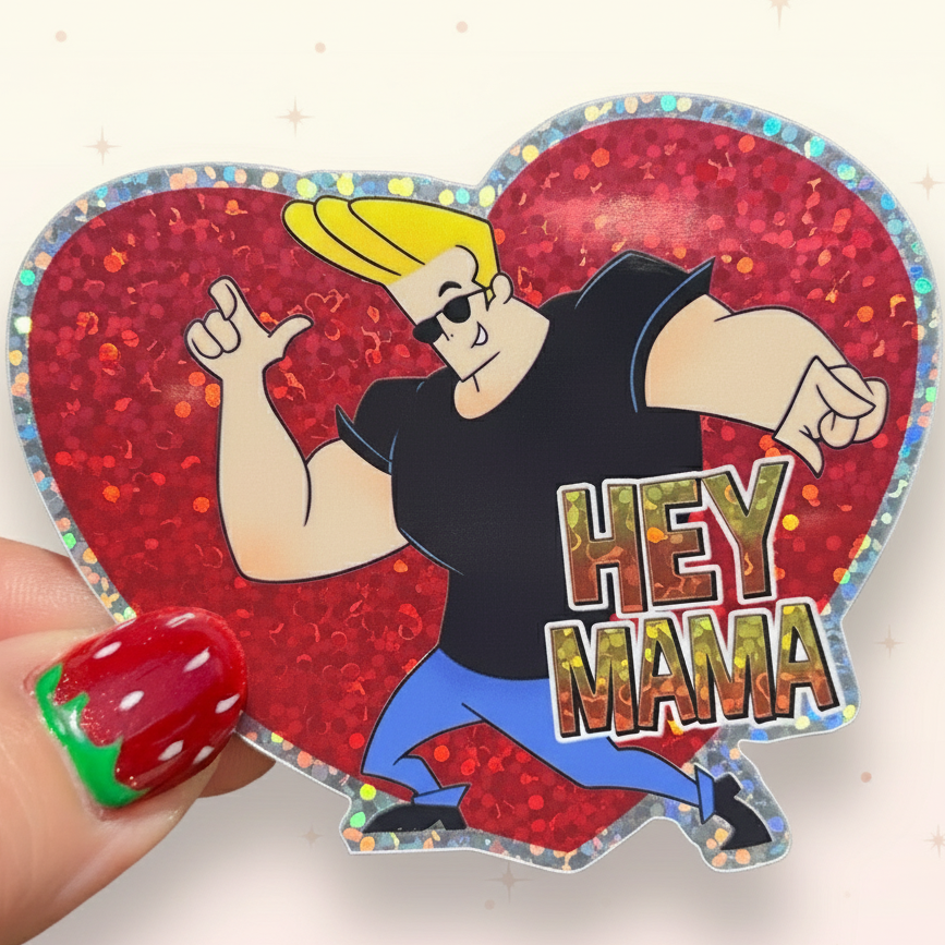 Heart-shaped glittery sticker with an animated character and 'HEY MAMA' text, held against a green leafy background.