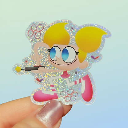 Cartoon character sticker held by a hand with a green leafy background