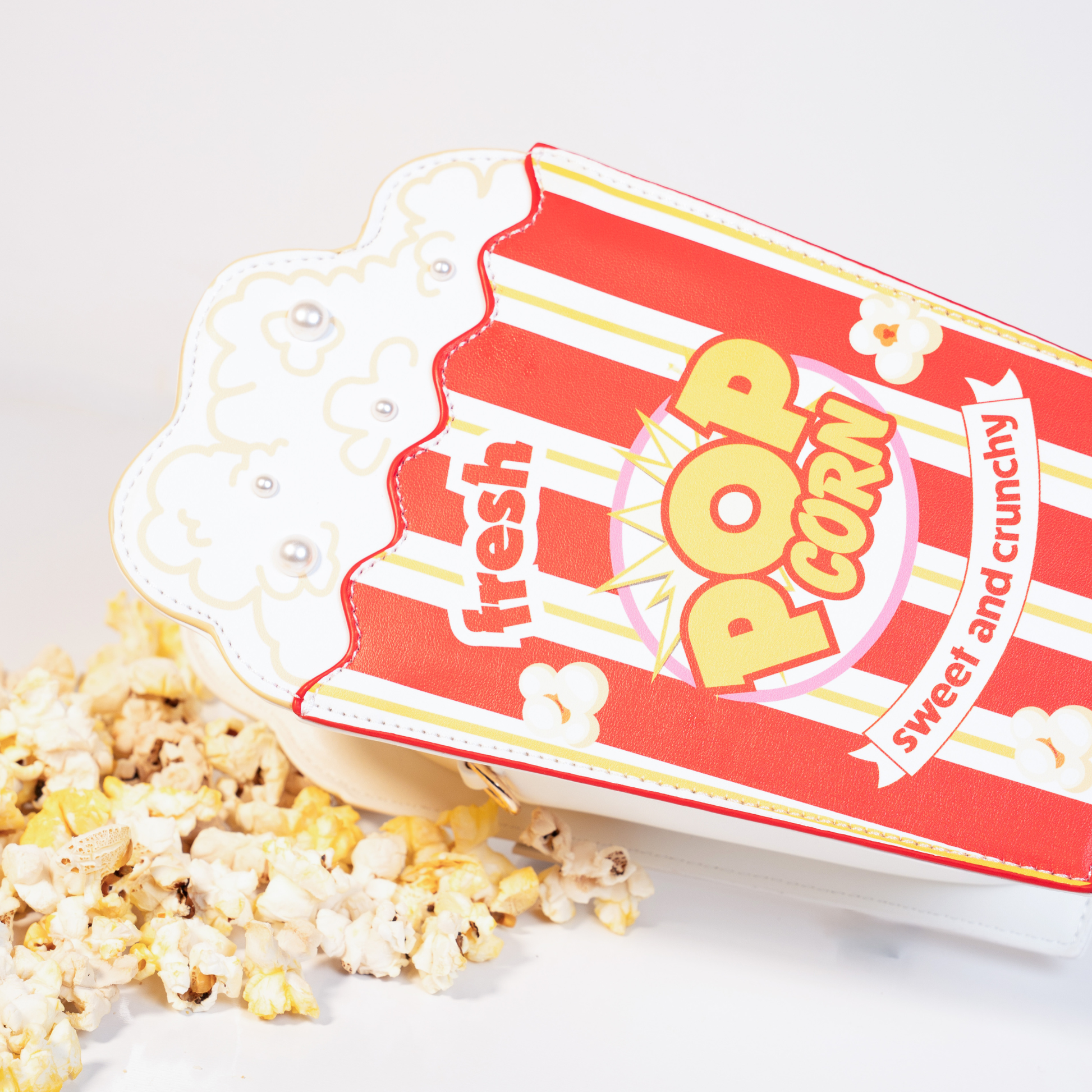 Popcorn crossbody bag side view showing red and white striped design detail