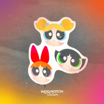 Three cartoon characters with colorful hair on a gradient background with 'Imagination Station' text.