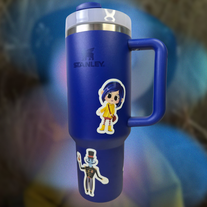 Blue Stanley tumbler with cartoon character stickers on a blurred background