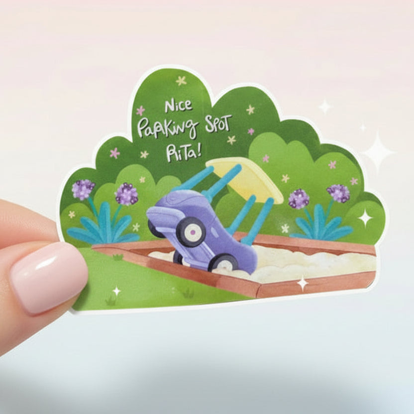 Hand holding a small decorative sign with a cartoon car and text on a white background