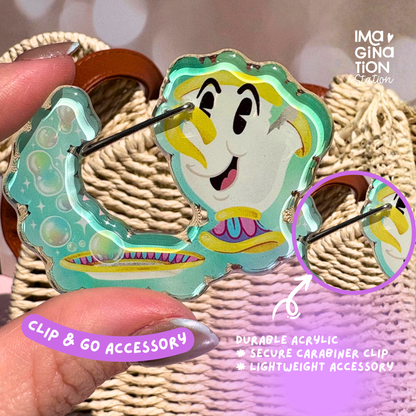Colorful clip accessory with a cartoon character design held by a hand against a textured background.
