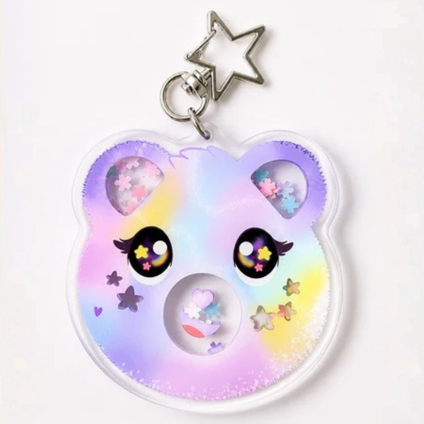 A pastel rainbow bear-shaped keychain with glitter-filled eye windows, a silver star-shaped keyring, and cute cartoon eyes, shown on a plain white background.