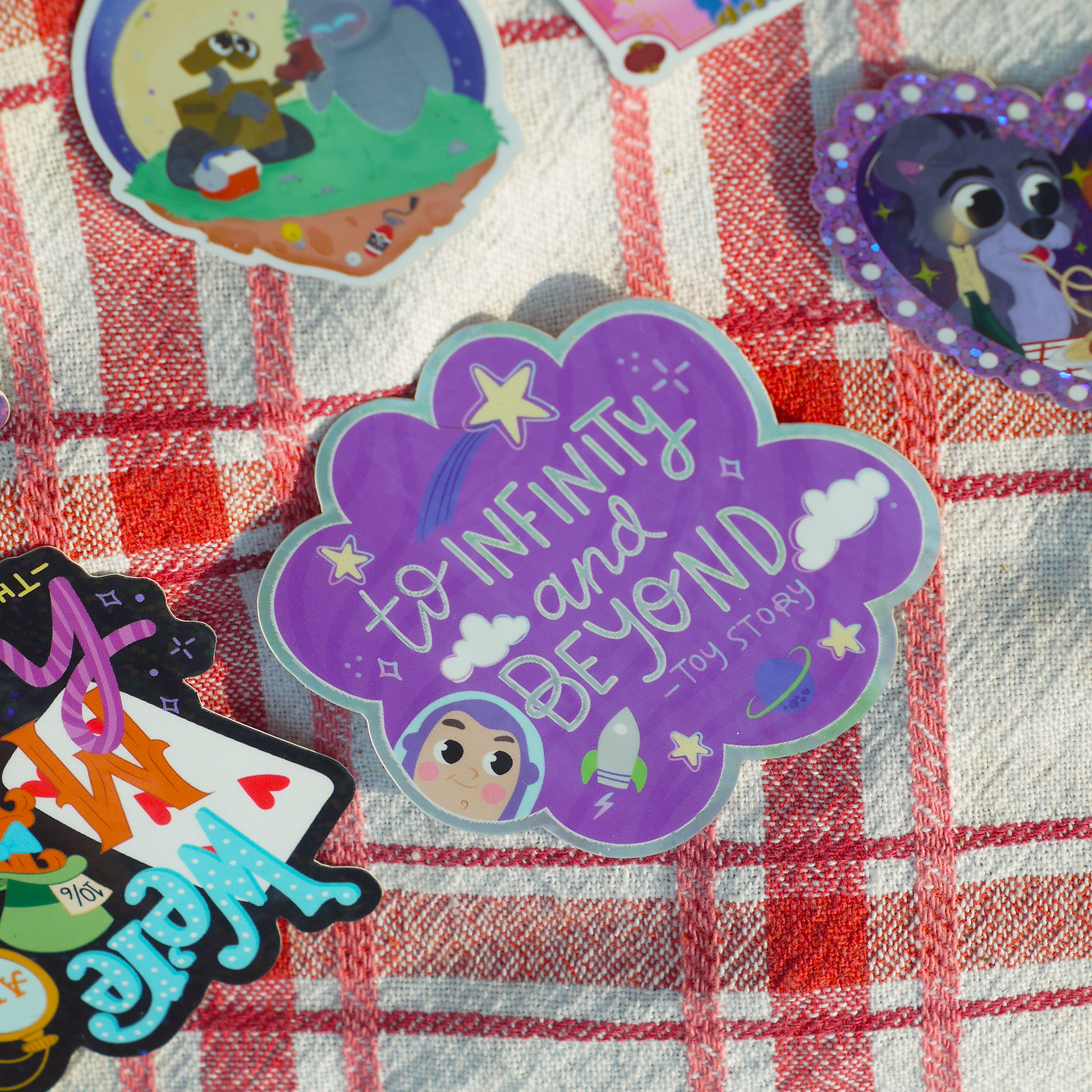 Colorful 'To Infinity and Beyond' toy story-themed sticker on a checkered fabric background