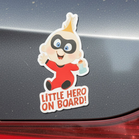 Car magnet with baby superhero character and 'Little Hero on Board!' text on a colorful background