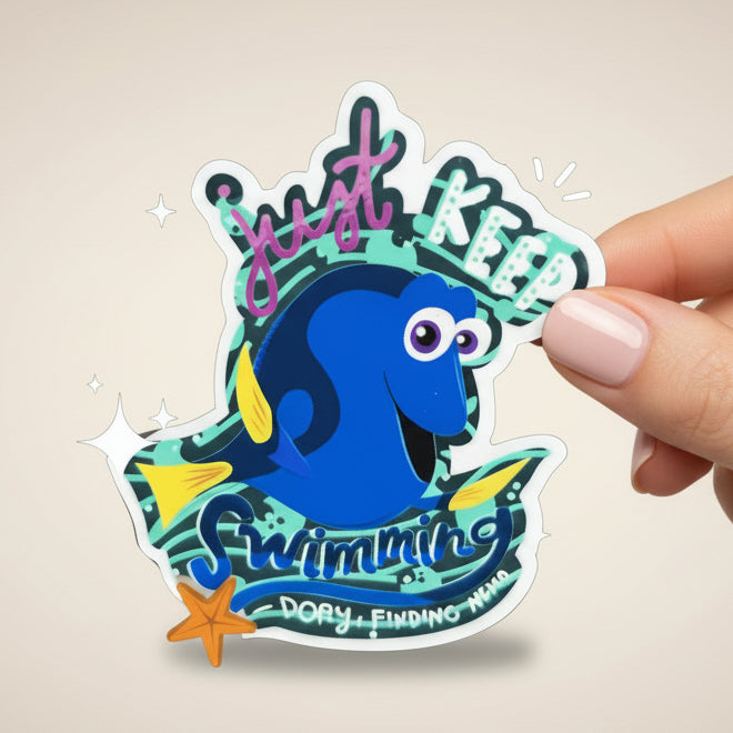 Sticker of Dory from 'Finding Nemo' with text 'Just Keep Swimming' on a blue background.