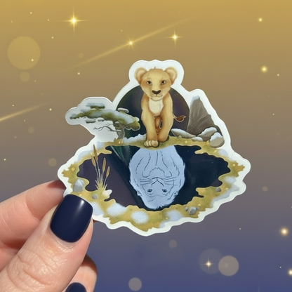 Hand holding a sticker with a lion design outdoors