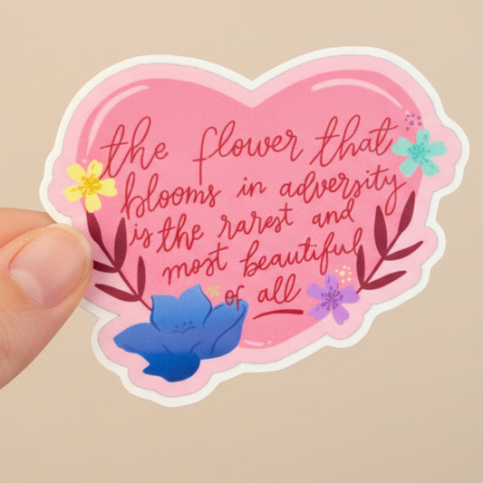 Heart-shaped pink sticker with motivational quote on a green leafy background