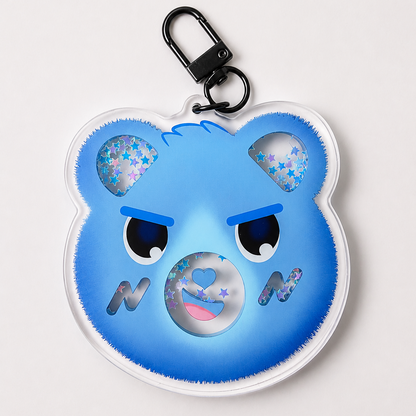 A blue bear-shaped keychain with a black carabiner clip, featuring glittery star details in the ears and a glittery circular mouth on a light gray background.