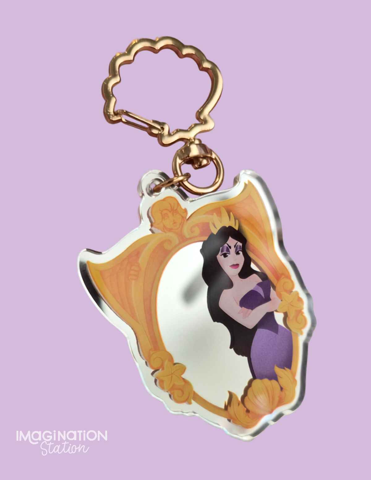 A Disney-themed acrylic keychain featuring Ursula from The Little Mermaid inside a gold ornate frame, attached to a gold lobster clasp, set against a solid lavender background.