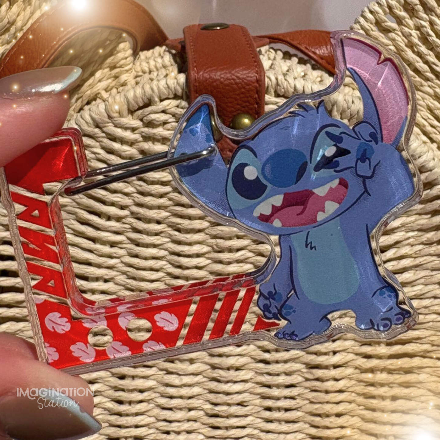 Blue cartoon character keychain with red and white patterned strap on woven surface